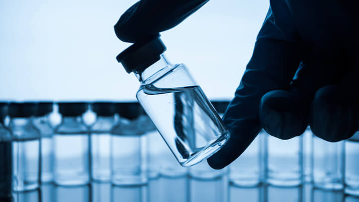 Hand holding vials