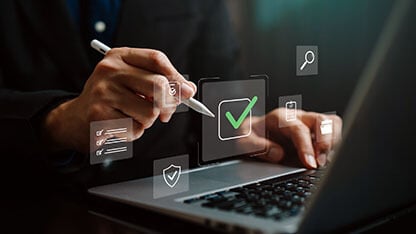 Hand using stylus on laptop with digital checkmark and checklist icon, representing approval workflow, task completion, compliance review, quality control, verification process, business management