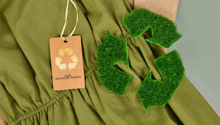 Green and beige eco friendly cotton fabric with 100 percent recycled label and recycling symbol made out of grass