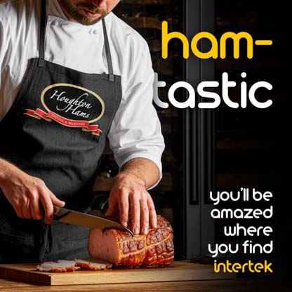 A man slicing ham while wearing a Houghton Hams apron